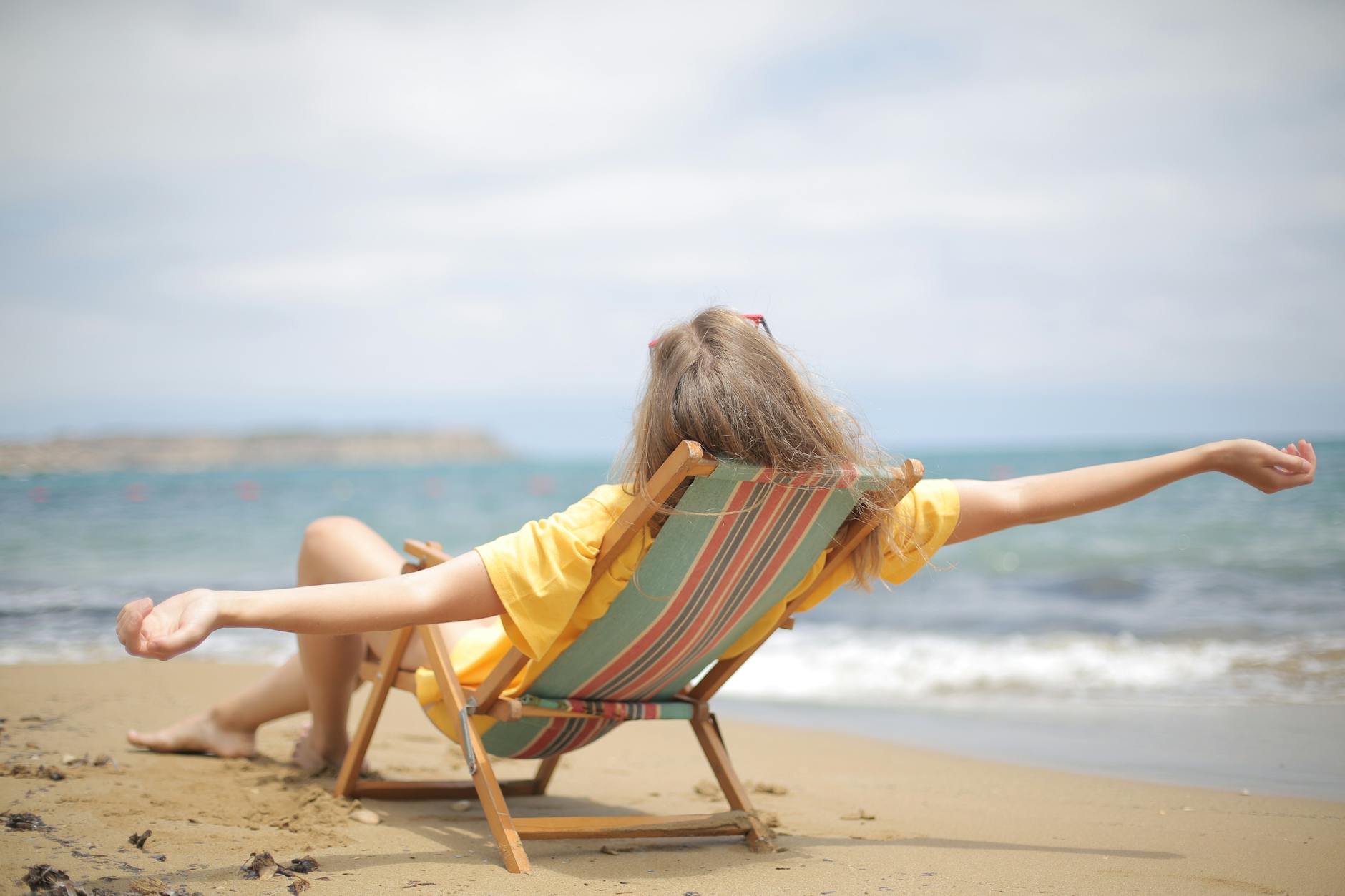 photo of woman reclining on wooden folding chair