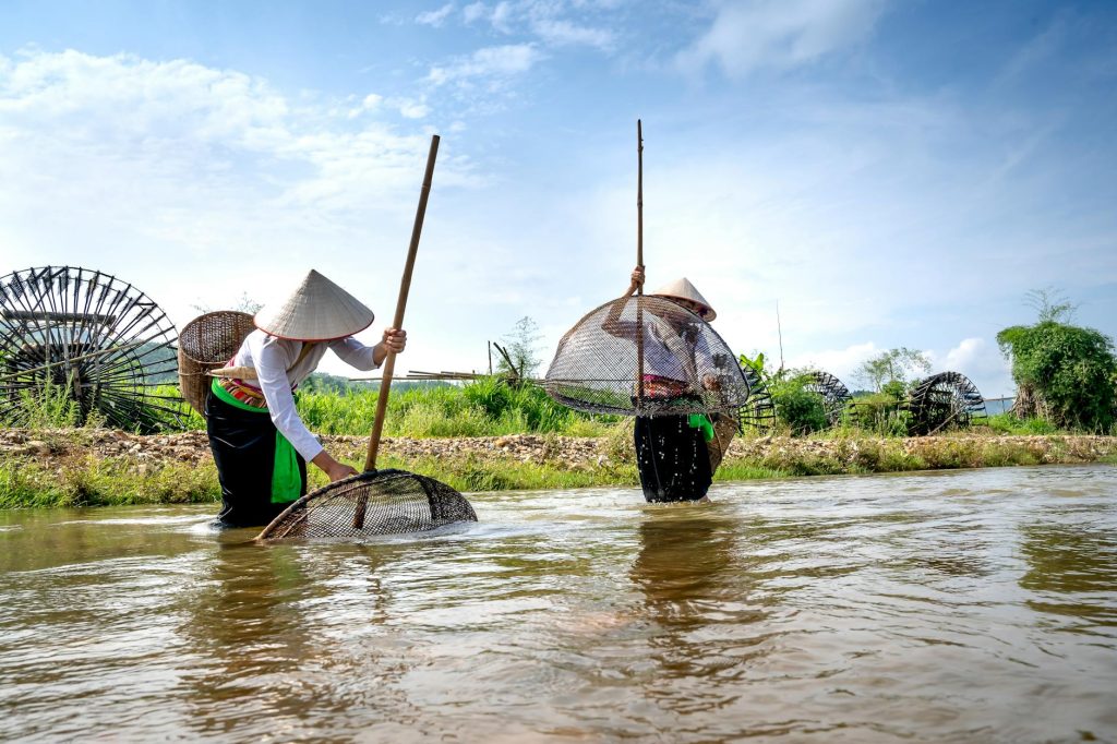 female anglers catching fish in pond