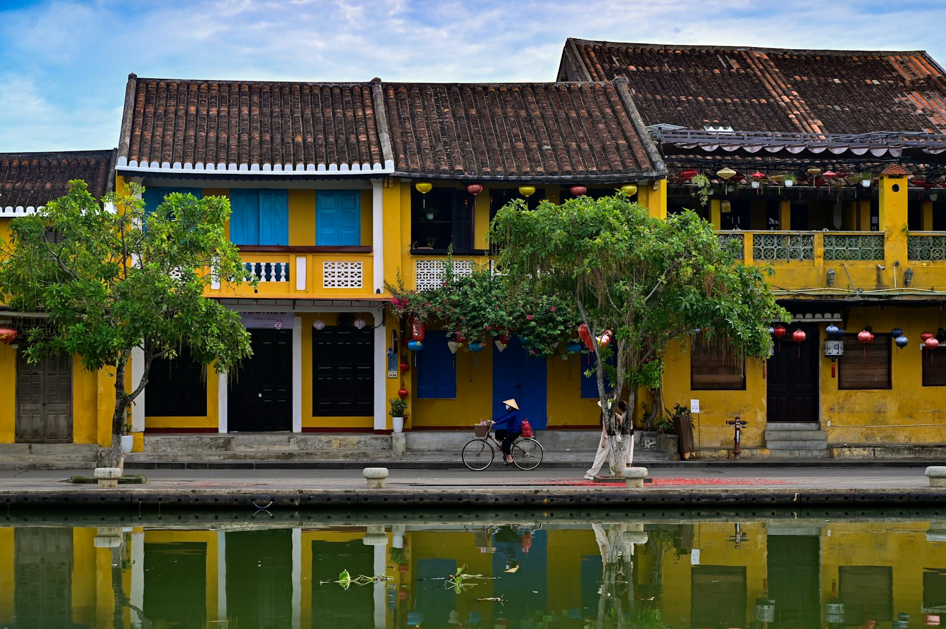 tradicional yellow houses by the canal and a cyclist riding along the promenade
