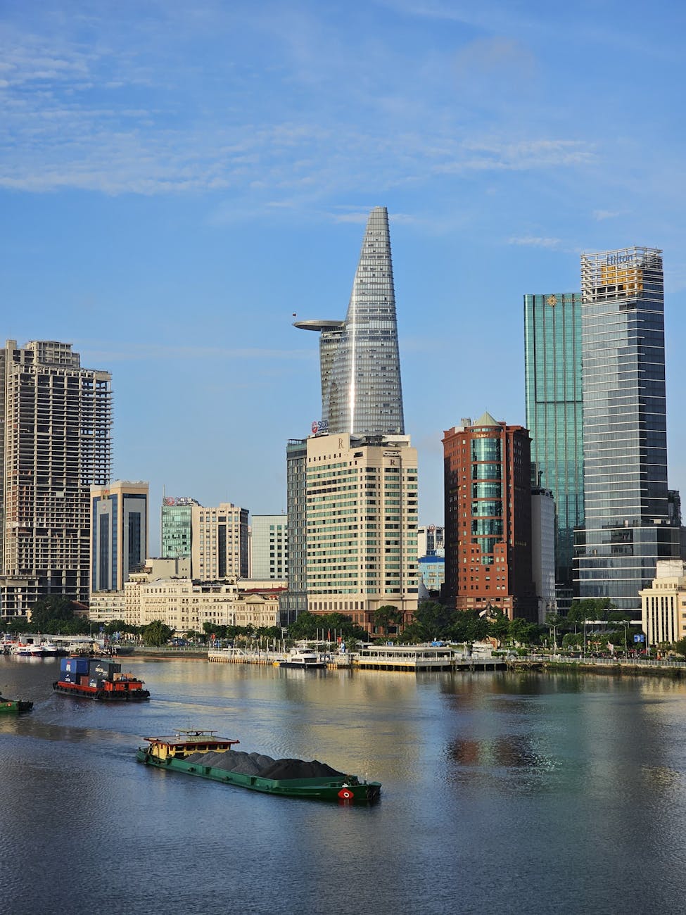 a city skyline with many tall buildings and boats