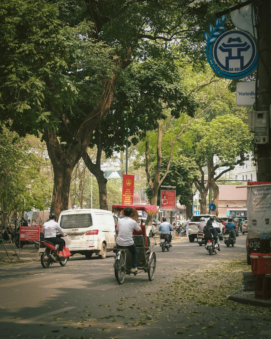 street view of hanoi with cyclo and motorbikes