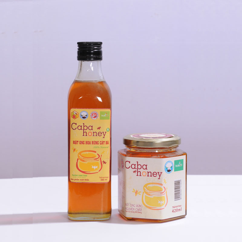 A bottle and a jar of Caba honey, showcasing clear amber honey products with colorful labels emphasizing their natural quality.